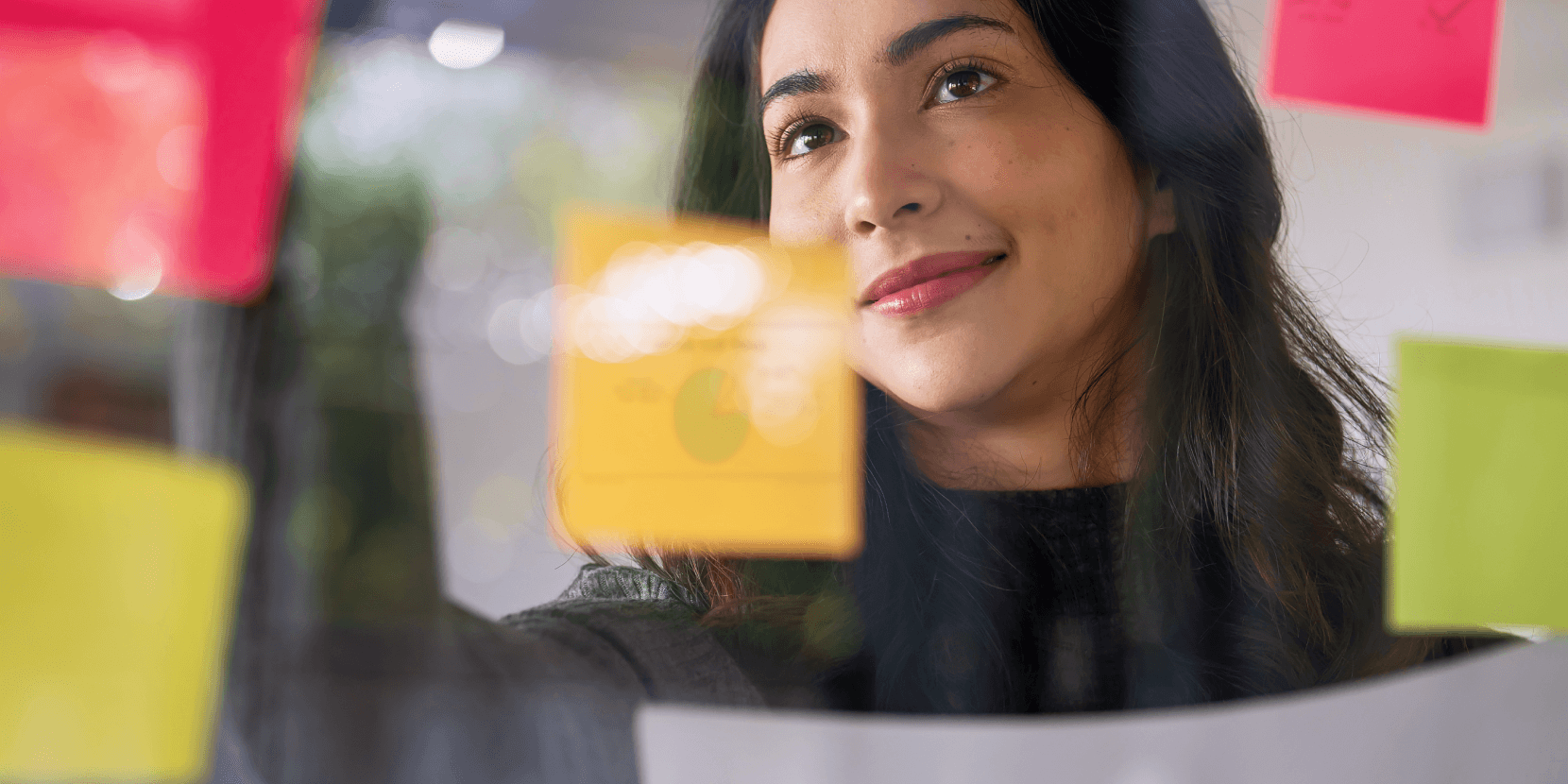 Woman smiling brain storming with post-it notes