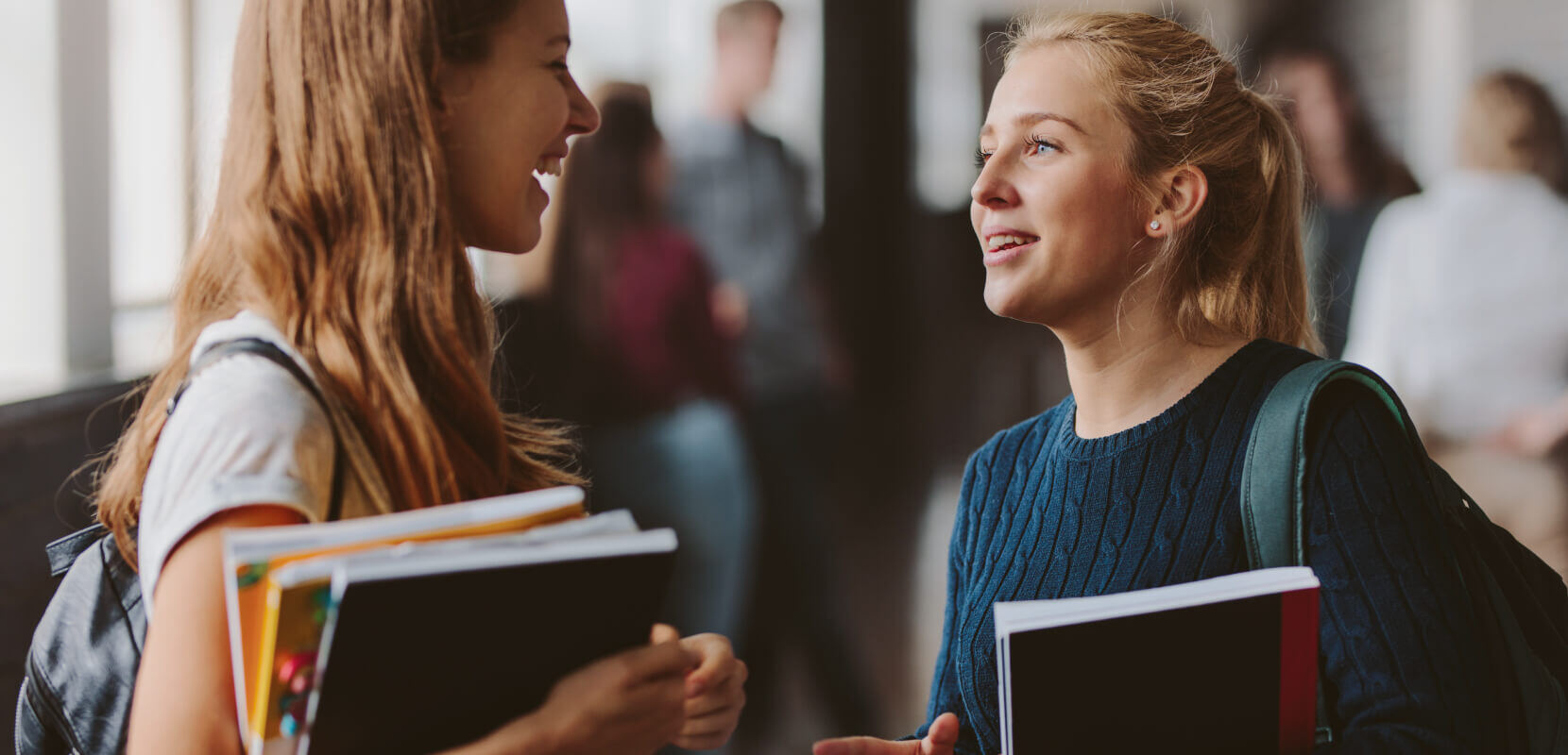 Two high school students talking in the school hall